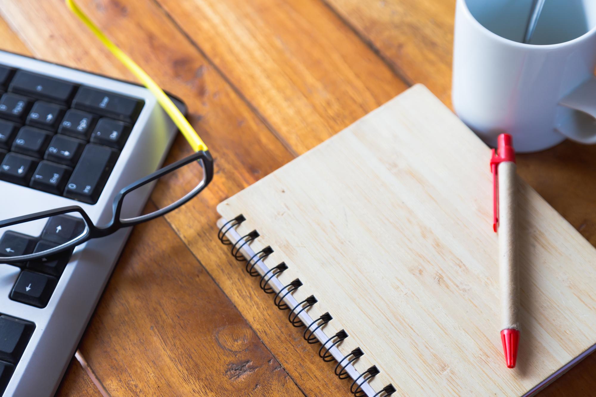 Praxis-Workbook und Stift auf Tisch